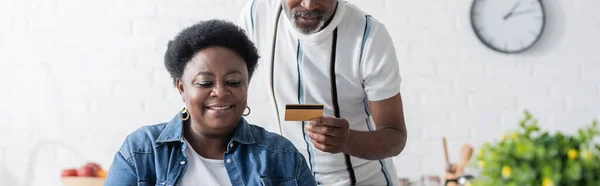 Starszy Afroamerykanin Mężczyzna Trzyma Kartę Kredytową Pobliżu Szczęśliwej Żony Baner — Zdjęcie stockowe