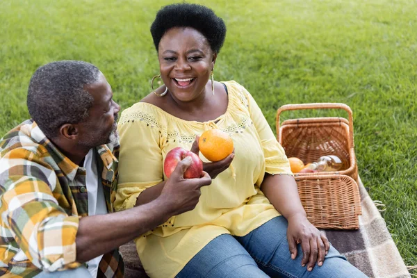 Mutlu Yaşlı Afrikalı Amerikalı Çift Piknik Sırasında Meyve Tutuyorlar — Stok fotoğraf