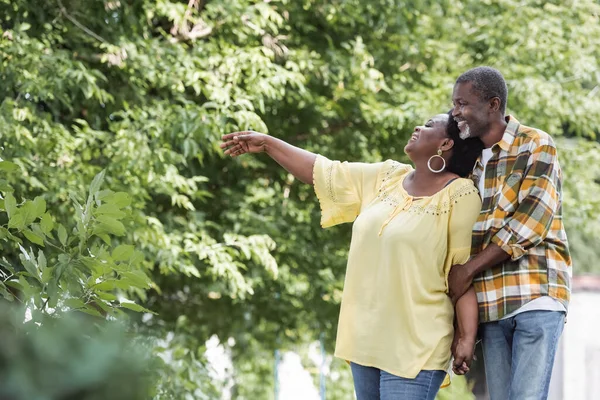 Feliz Sénior Afroamericano Mujer Apuntando Con Mano Cerca Marido Parque —  Fotos de Stock