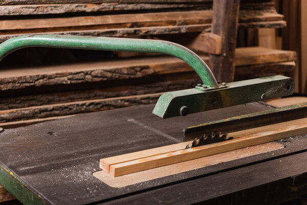 plank on workbench with circular saw in woodwork studio