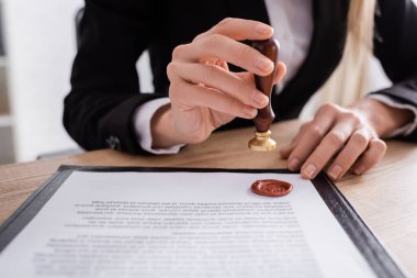 cropped view of notary stamping contract with wax seal clipart
