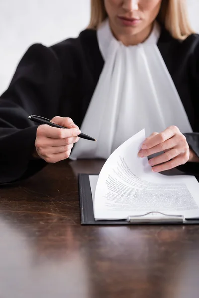 Partial View Blurred Judge Holding Pen Lawsuit Clipboard — Photo