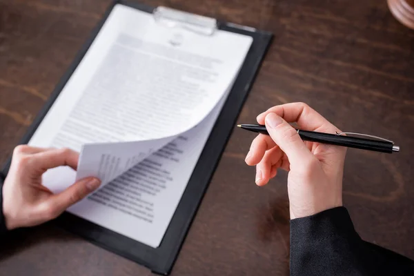 Top View Cropped Judge Holding Pen Blurred Lawsuit Clipboard — Foto de Stock