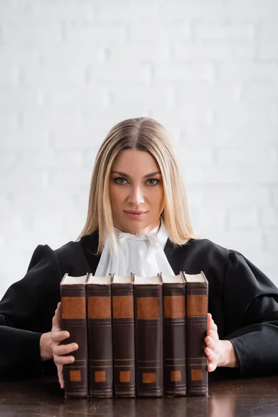 Blonde Prosecutor Mantle Looking Camera Collection Books — Stockfoto