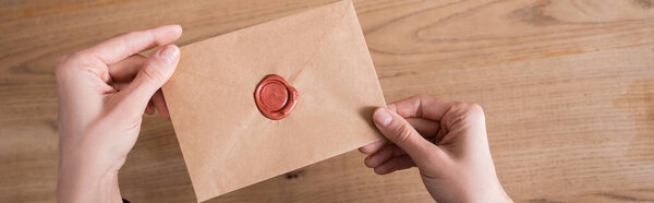 верхний вид бумажного конверта с восковой печатью в руках обрезанного нотариуса, баннер