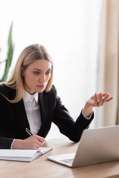 Rubia Notario Gesto Cerca Computadora Portátil Mientras Que Celebración Pluma —  Fotos de Stock