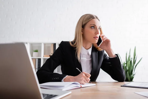 Blond Notarie Talar Mobiltelefon Nära Bärbar Dator Och Suddig Bärbar — Stockfoto