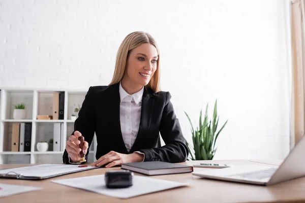 Leende Notarie Tittar Bärbar Dator Medan Stämpling Kontrakt Kontor — Stockfoto