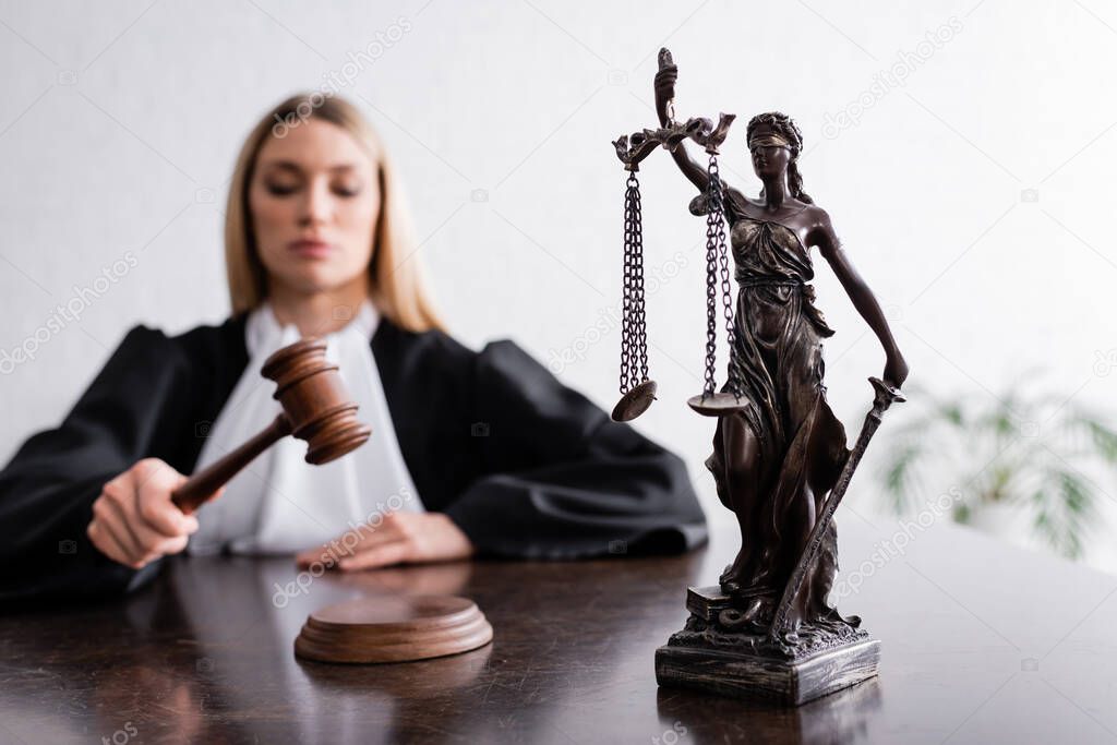 selective focus of themis statue near judge with gavel on blurred background