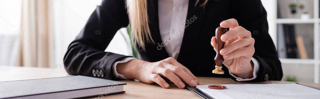 cropped view of lawyer with stamper near notebook and contract, banner