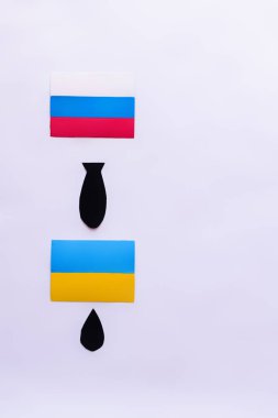 Top view of paper bomb between russian and ukrainian flags on white background, war in ukraine concept  clipart