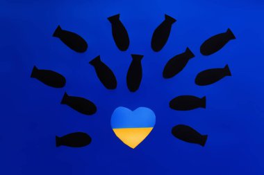 Ukrayna bayrağı üzerinde mavi arka planda kalp şeklinde kağıt bombalarının üst görünümü 