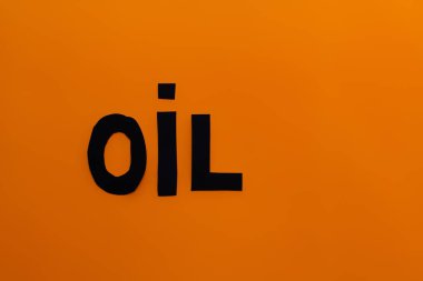 Top view of paper oil word on orange background  clipart