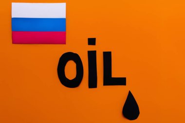 Rus bayrağının üst görüntüsü, petrol harfleri ve turuncu arka planda kağıt damlaları, Ukrayna konseptinde savaş 