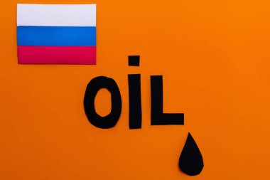 Top view of russian flag, oil lettering and paper drop on orange background, war in ukraine concept  clipart