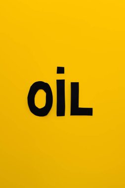 Top view of paper oil word on yellow background  clipart