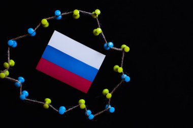 Top view of russian flag near push pins with thread isolated on black, war in ukraine concept  clipart