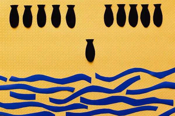 纸制炸弹在黄色纹理背景的抽象纸盒海上方的俯视图 — 图库照片