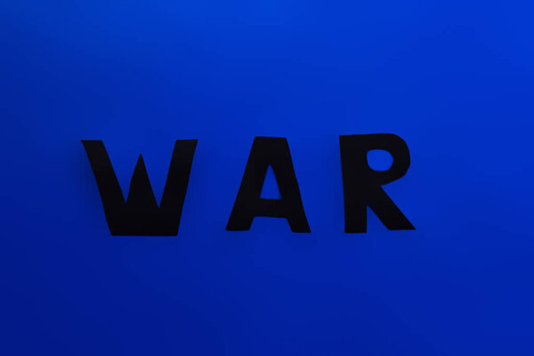 Top view of paper war lettering on blue background 