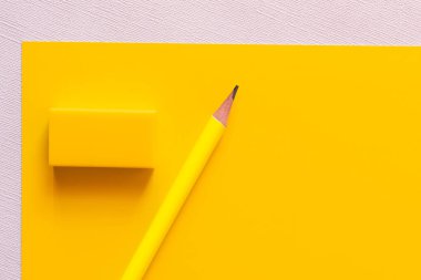 Sarı ve beyaz üzerine silginin yanındaki kalemin üst görünümü