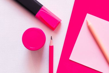 Kırtasiye malzemesi ve kavanozun üst görünümü, beyaz ve pembe desenli kağıda yakın.