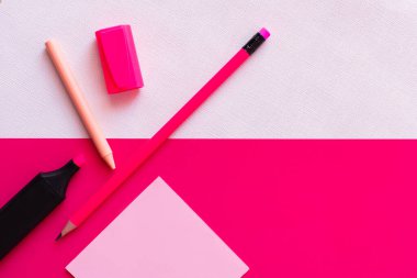 Kavanozun yanındaki kırtasiye malzemesinin üst görüntüsü boya ve desenli beyaz ve pembe üzerine boş kağıt notla