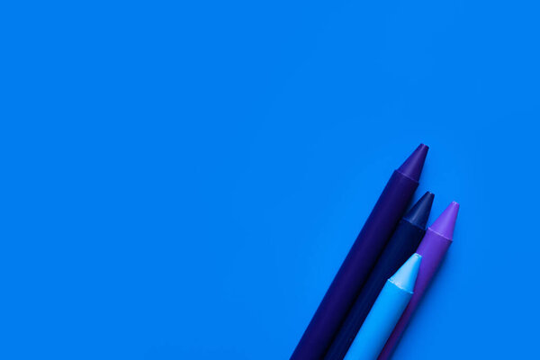 top view of gradient crayons on bright blue background