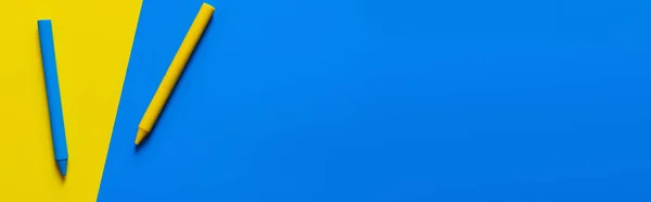 青と黄色の背景のクレヨンの上からの眺めバナー — ストック写真