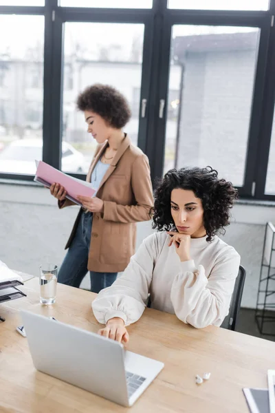 Arabian Businesswoman Using Laptop Blurred African American Colleague Papers Office — Stockfoto