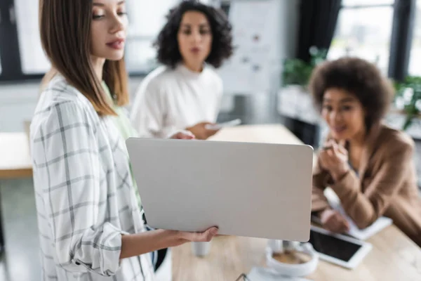 Laptop Mão Empresária Turva Trabalhando Com Colegas Inter Raciais Escritório — Fotografia de Stock