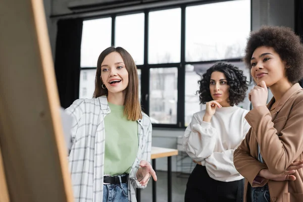 Fröhliche Multiethnische Geschäftsfrauen Blicken Auf Verschwommenes Brett Amt — Stockfoto