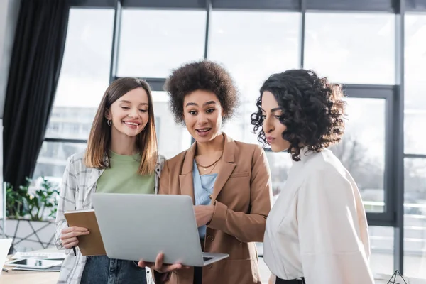 Mulheres Negócios Multiculturais Alegres Olhando Para Laptop Escritório — Fotografia de Stock