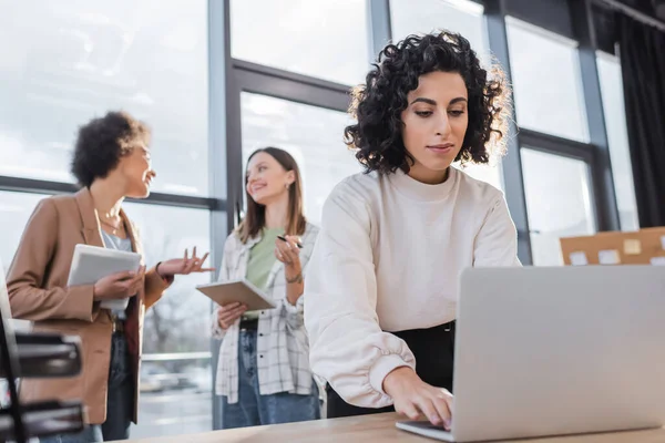 Muslim Businesswoman Using Laptop Blurred Multiethnic Colleagues Talking Office — стокове фото