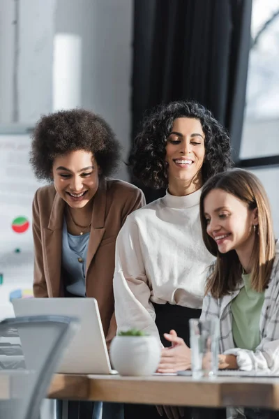 Gelukkige Multiculturele Zakenvrouwen Zoek Naar Wazig Laptop Het Kantoor — Stockfoto