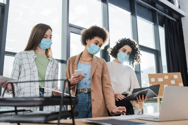 Interracial Businesswomen Protective Masks Holding Gadgets Working Papers Office — Stock Photo, Image