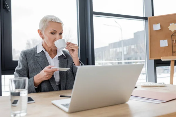 Stylish Senior Banker Drinking Coffee Laptop Blurred Glass Water — Stock Photo, Image