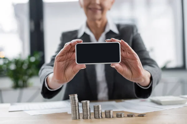 Cropped View Blurred Banker Holding Cellphone Blank Screen Stacks Silver — Stock Photo, Image