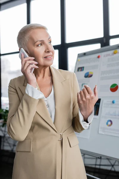 Senior Businesswoman Talking Mobile Phone Blurred Flip Chart — Stockfoto
