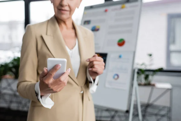 Partial View Banker Holding Smartphone Flipchart Blurred Background — Zdjęcie stockowe