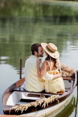 Mutlu genç çift romantik tekne gezisi sırasında sarılıyor.