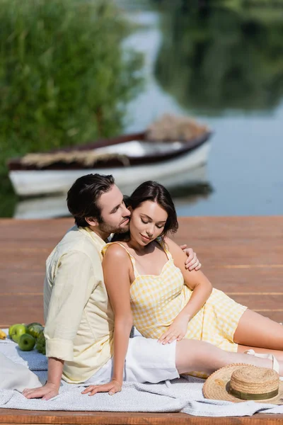 Uomo Abbraccio Bella Donna Mentre Seduto Sul Molo Durante Picnic — Foto Stock