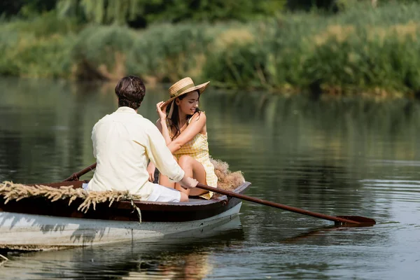 戴着草帽的快乐女人和男人一起坐浪漫的船 — 图库照片
