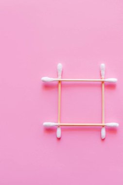 Pembe arkaplanda pamuklu çubuklardan yapılmış kare görünümü
