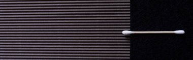 top view of cotton ear stick on black textured background with copy space, banner