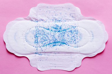 top view of white panty liner with sequins on violet background