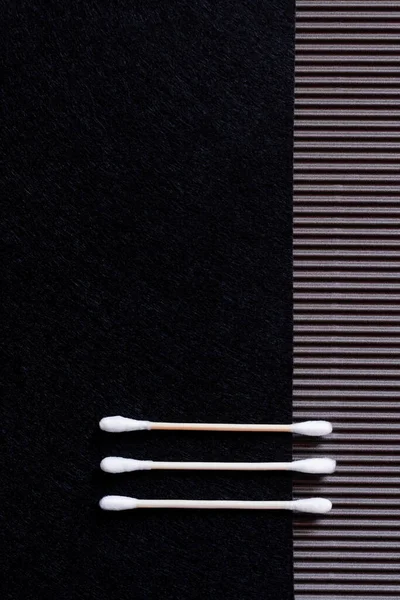 黒とテクスチャの背景に2本の綿の耳の棒の上からの眺め — ストック写真