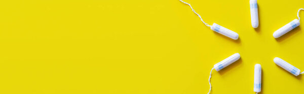 top view of circle made of tampons on yellow background with copy space, banner