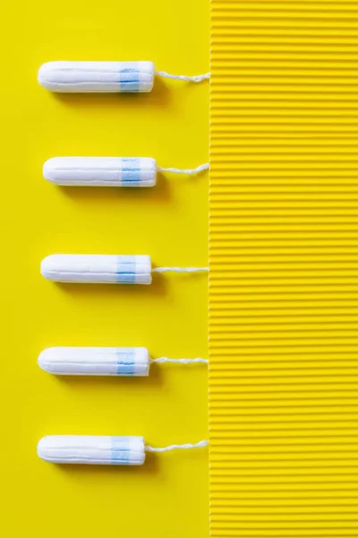Top View Vertical Row Tampons Yellow Textured Background — стоковое фото
