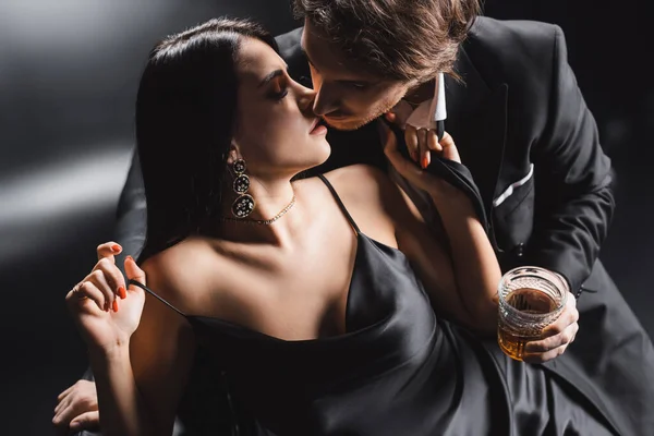 Sexy Casal Guerra Formal Segurando Uísque Beijando Sofá Fundo Preto — Fotografia de Stock