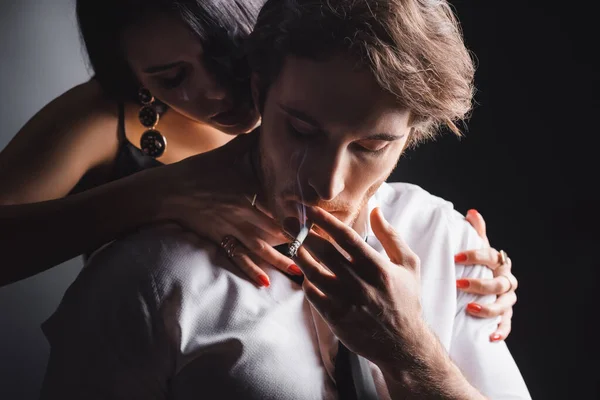 Passionate Woman Embracing Boyfriend Shirt Smoking Cigarette Black Background — Stockfoto